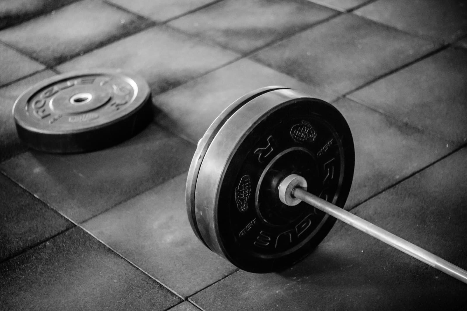 Barbell and a loose plate on a gym floor, the training habit creatine is for
