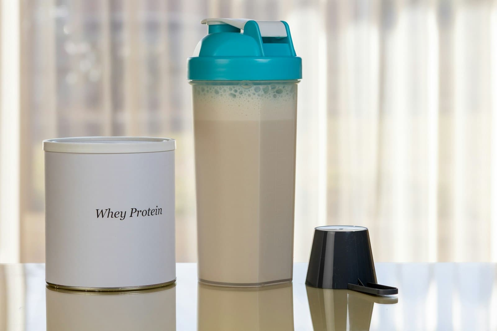 Unlabeled powder tub beside a mixed shaker bottle, the mix-and-drink habit
